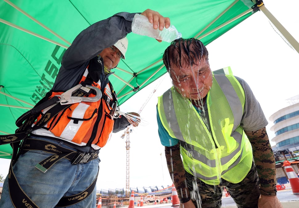 Des ouvriers sud-coreens se rafraichissent sur un chantier de construction