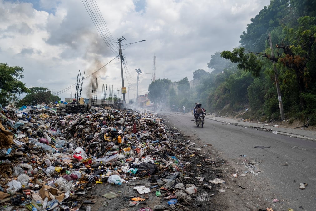 Des dechets brulent sur le bord d'une route a port-au-prince, en haiti