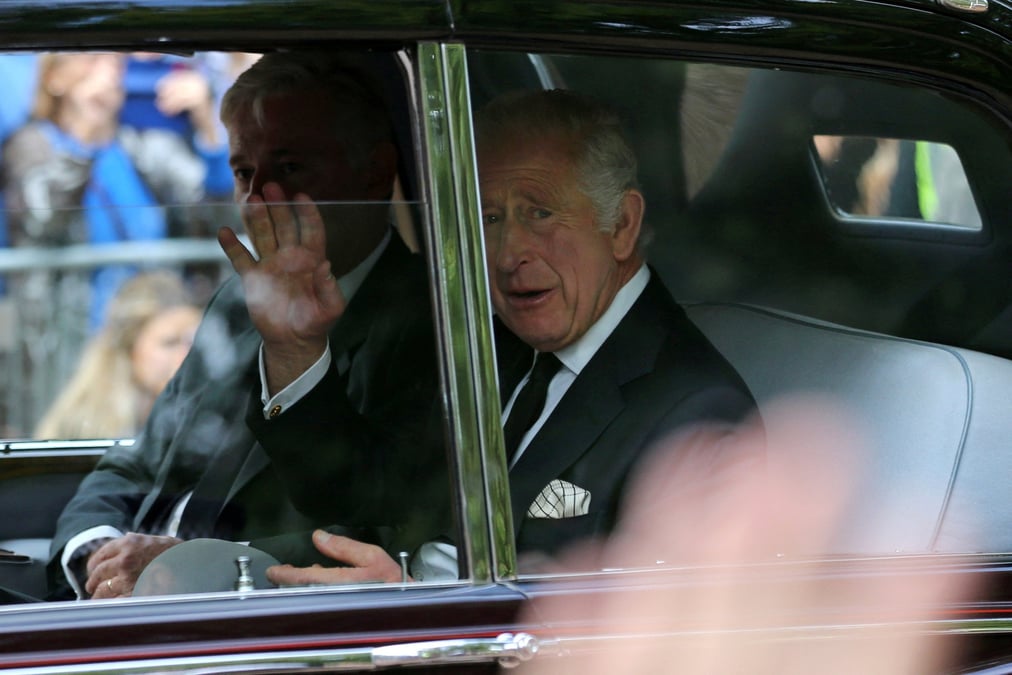 Le roi charles iii salue la foule alors que son vehicule traverse le centre de londres