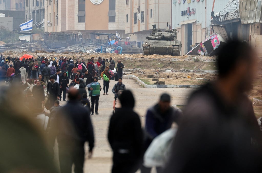 Un char israelien se place au coeur des debris, alors que les palestiniens fuient