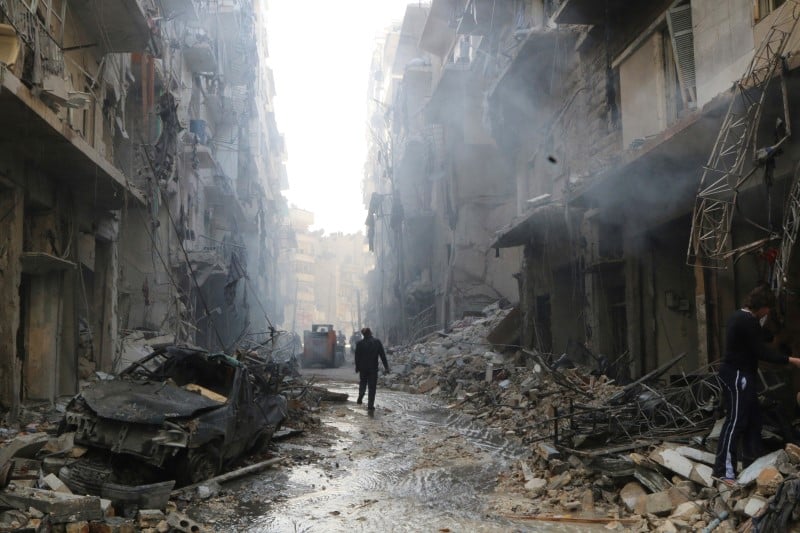 People inspect damage at a site hit by what activists said were barrel bombs dropped by forces loyal to syria's president al-assad in aleppo's district of al-sukari