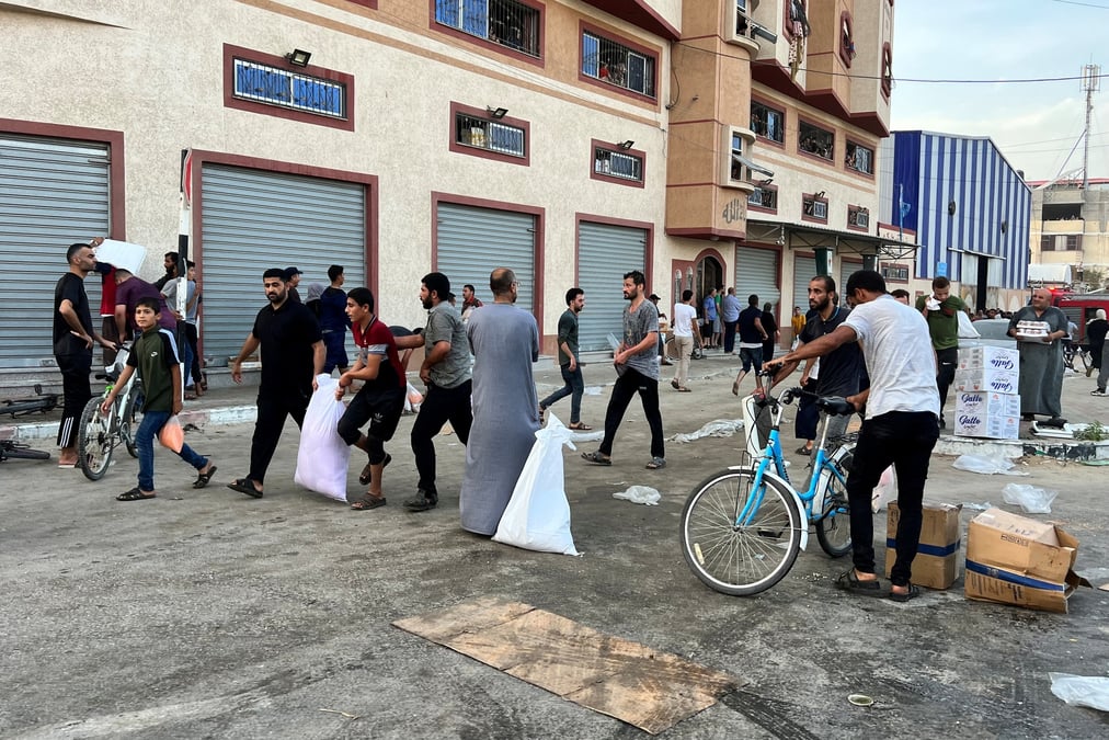 Des palestiniens transportent des vivres pres d'un entrepot gere par l'agence des nations unies pour les refugies palestiniens (unrwa) a khan younis