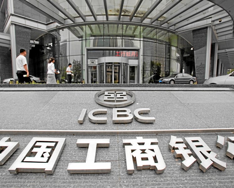 Pedestrians walk past a branch of the Industrial and Commercial Bank of China (ICBC) Ltd., in Beijing, China, on Thursday, July 29, 2010. ICBC, the world's largest lender by market value, said it will raise up to 45 billion yuan ($6.6 billion) in a rights offer to replenish capital. Photographer: Ne