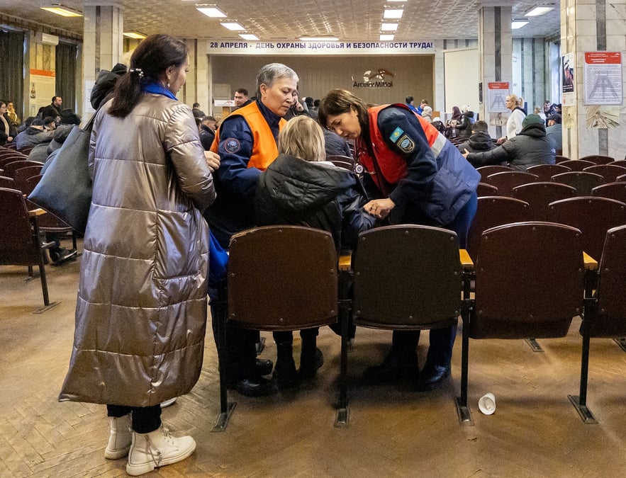 Une femme est aidee a la mine de charbon de kostenko, alors que des parents de mineurs se rassemblent lors d'une operation de sauvetage a la suite d'un incendie dans la mine, a karaganda