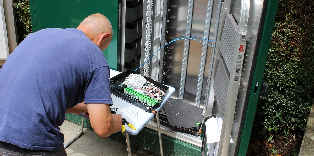 Un technicien raccorde des abonnés à la fibre.