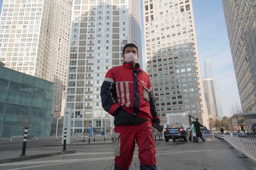Coronavirus / Covid-19 : un livreur KFC marche dans un complexe commercial situé dans le quartier des affaires de Beijing en Chine