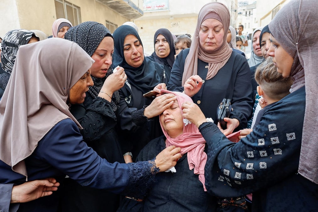 Des femmes consolent la mere du palestinien mateen dbaya, tue a la suite d'un raid des forces israeliennes dans le camp de refugies de djenine