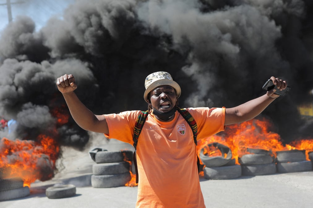 Un homme devant une barricade en feu lors d'une manifestation contre les recents meurtres de policiers par des gangs armes, a port-au-prince, haiti
