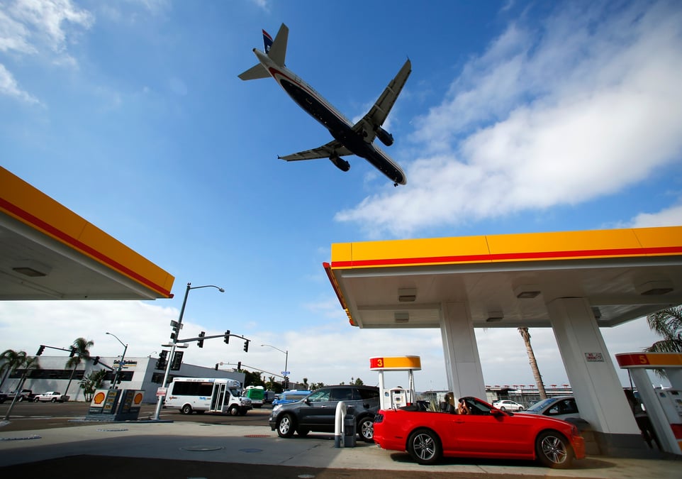 Un avion survole une station-service shell alors qu'il s'approche pour atterrir a l'aeroport de san diego en californie