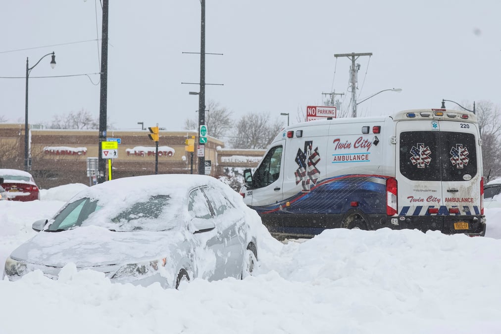Une ambulance passe devant une voiture abandonnee pendant une tempete hivernale qui a frappe la region de buffalo