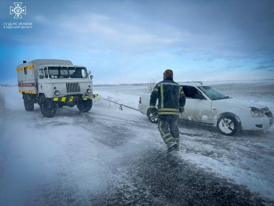 Photo des secouristes qui liberent une voiture coincee dans la neige suite a une forte tempete de neige dans la region d'odessa