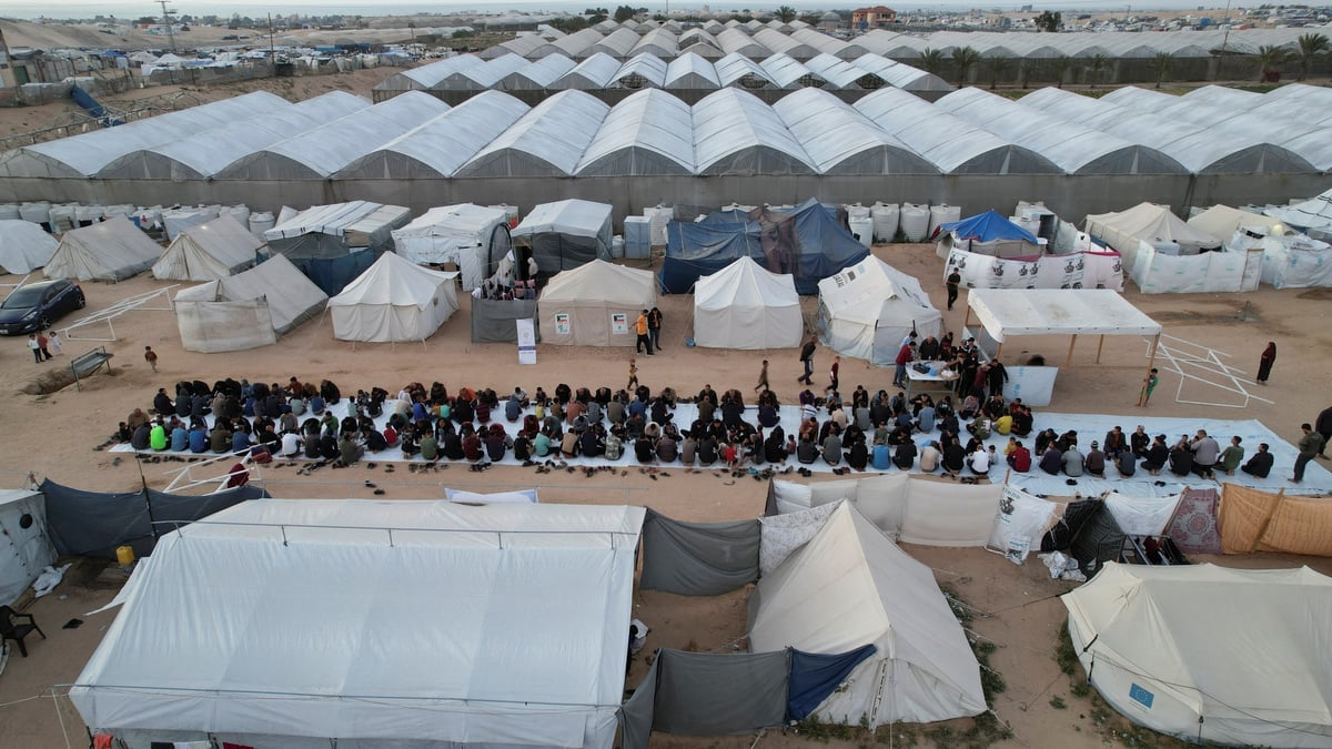 Une vue de drone montre des palestiniens, deplaces par l'offensive militaire israelienne, se rassemblant pour l'iftar (rupture du jeune) pendant le mois sacre du ramadan, a rafah, dans le sud de la bande de gaza
