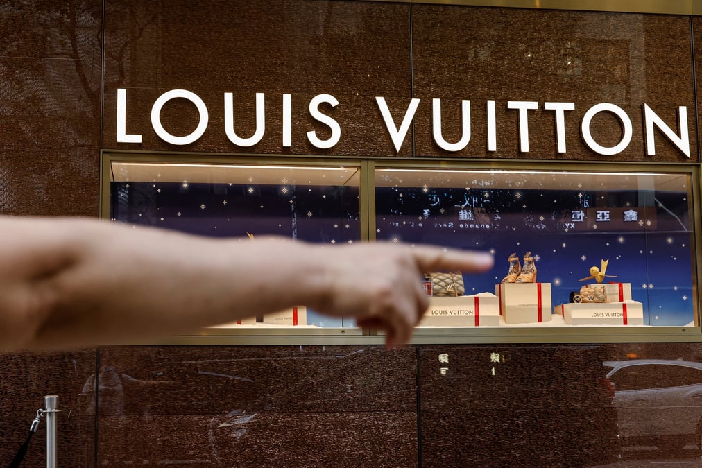 Un touriste devant un magasin louis vuitton a tsim sha tsui, un quartier commercant anime, a hong kong.