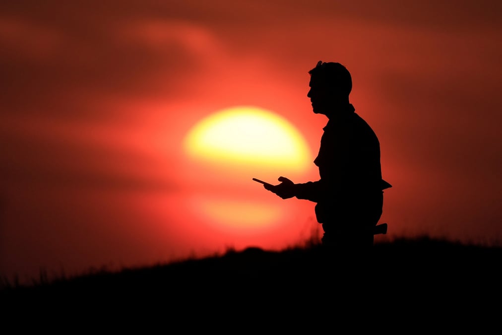 Un soldat israelien se tient sur une colline au coucher du soleil, pres de la frontiere entre israel et la bande de gaza