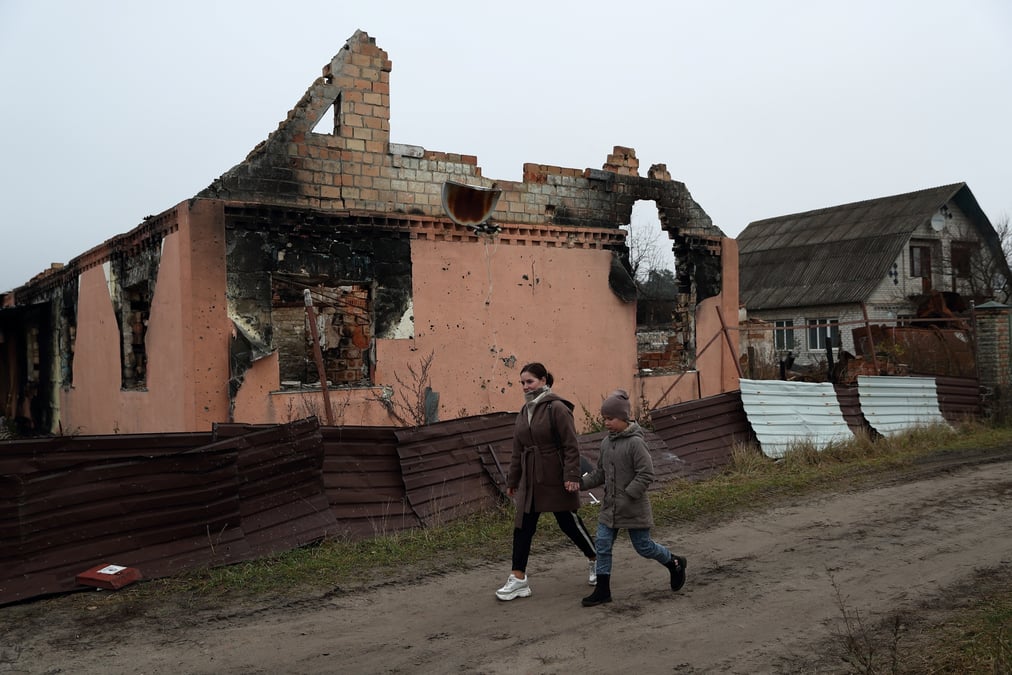 Kateryna tyshchenko et sa demi-soeur de 9 ans, yuliia zaika, passent devant une maison detruite dans le village de moshchun
