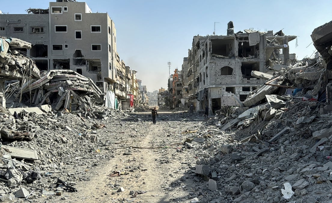 Un palestinien marche devant les decombres autour de l'hopital kamal adwan