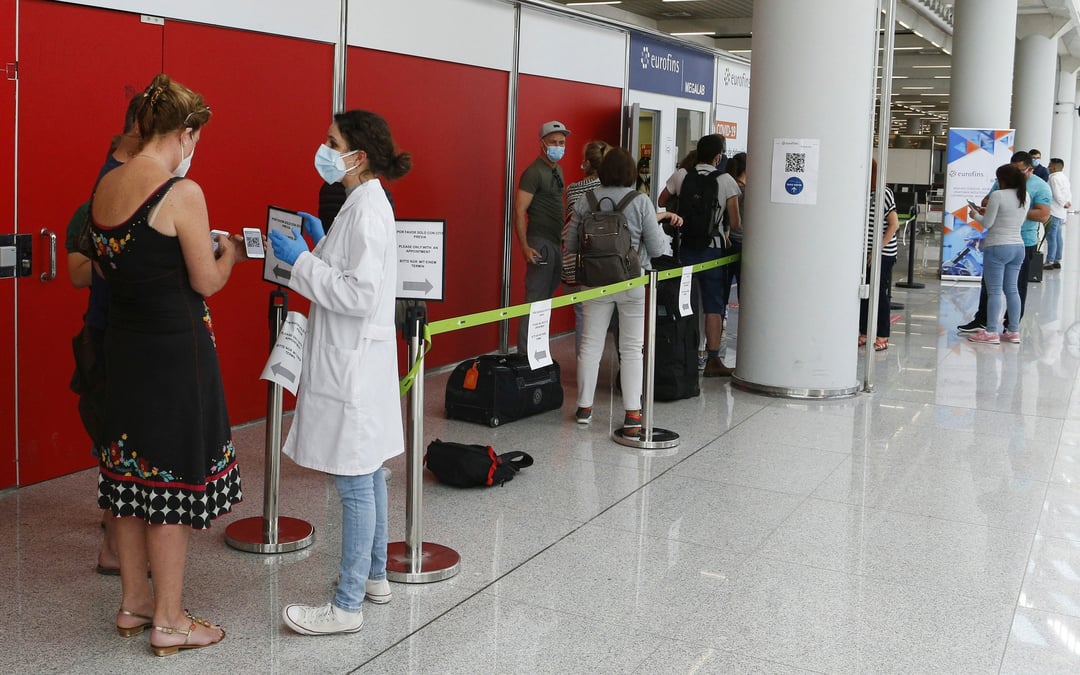 Des passagers font la queue devant un point de depistage du coronavirus a l'aeroport de son sant joan a palma de majorque