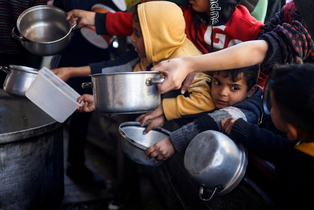 Des enfants palestiniens attendent de recevoir de la nourriture a rafah