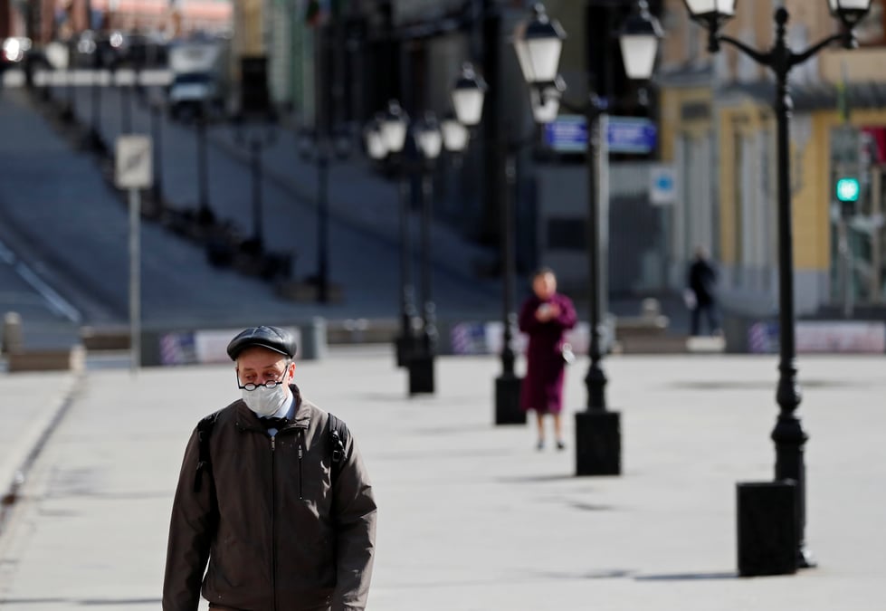 A man wearing a protective face mask walks along the street in moscow