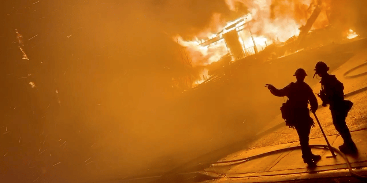 Deux pompiers devant une maison en feu lors d’incendies de forêt, le 31 octobre 2019 à San Bernardino, en Californie (capture d’écran obtenue à partir d’une vidéo de média social).