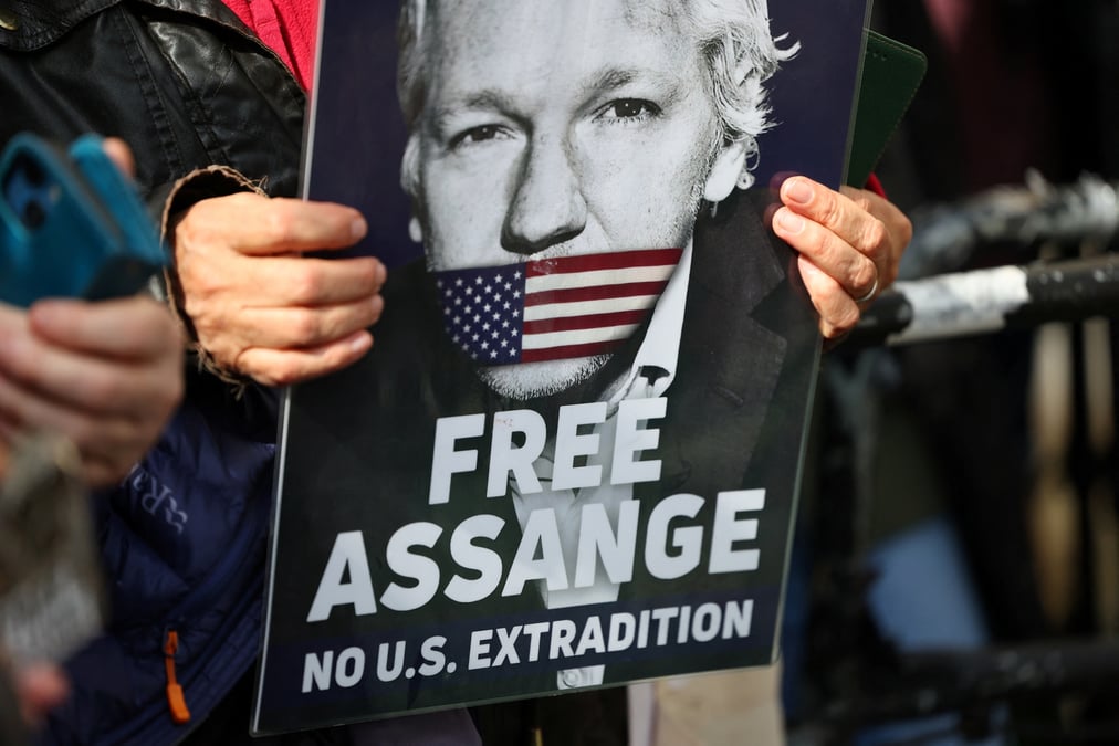 Photo d'un partisan du fondateur de wikileaks, julian assange, qui tient une pancarte