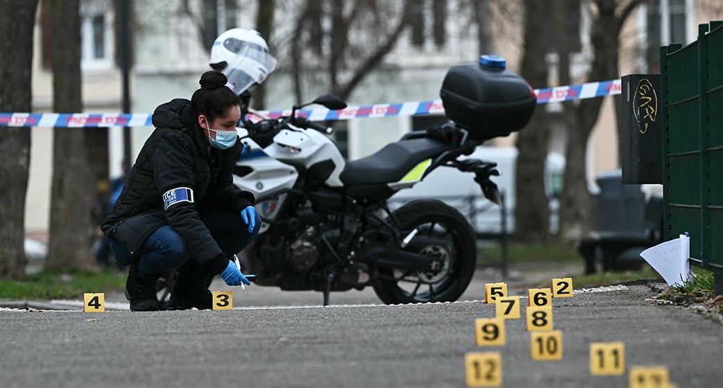 Une enquêtrice de la police judiciaire recueille des preuves sur le site de l’attaque à l'arme blanche où un homme est soupçonné d'avoir tué une personne et blessé deux policiers municipaux à Mulhouse ce 22 février.