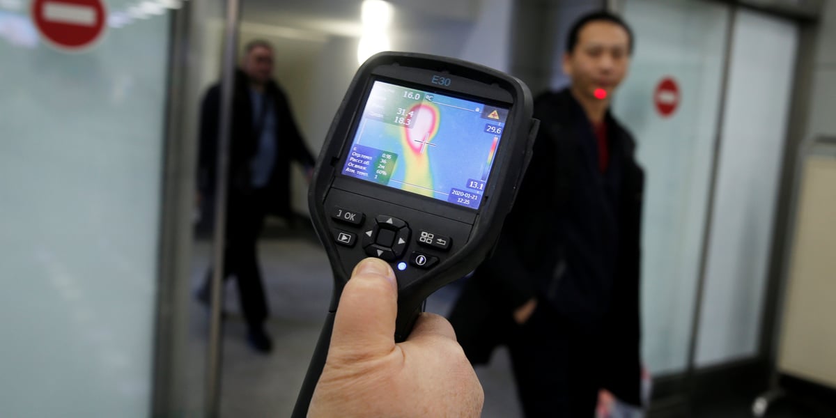 Le 21 janvier 2020, à l'aéroport international, un employé des services sanitaires et épidémiologiques kazakh utilise un scanner thermique pour détecter les voyageurs en provenance de Chine à leur arrivée au Kazakhstan qui pourraient présenter des symptômes liés au nouveau coronavirus chinois .