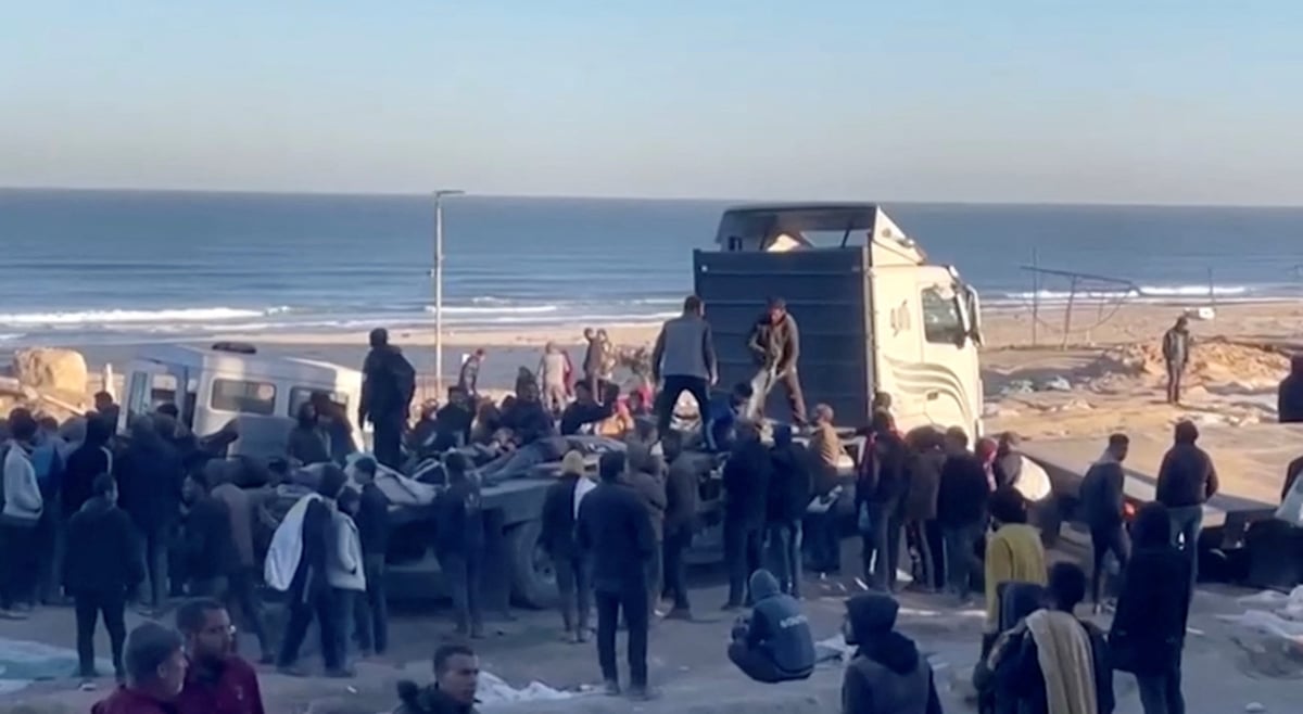 Des palestiniens transportent des blesses a la suite de tirs israeliens sur des personnes attendant de l'aide, dans la ville de gaza