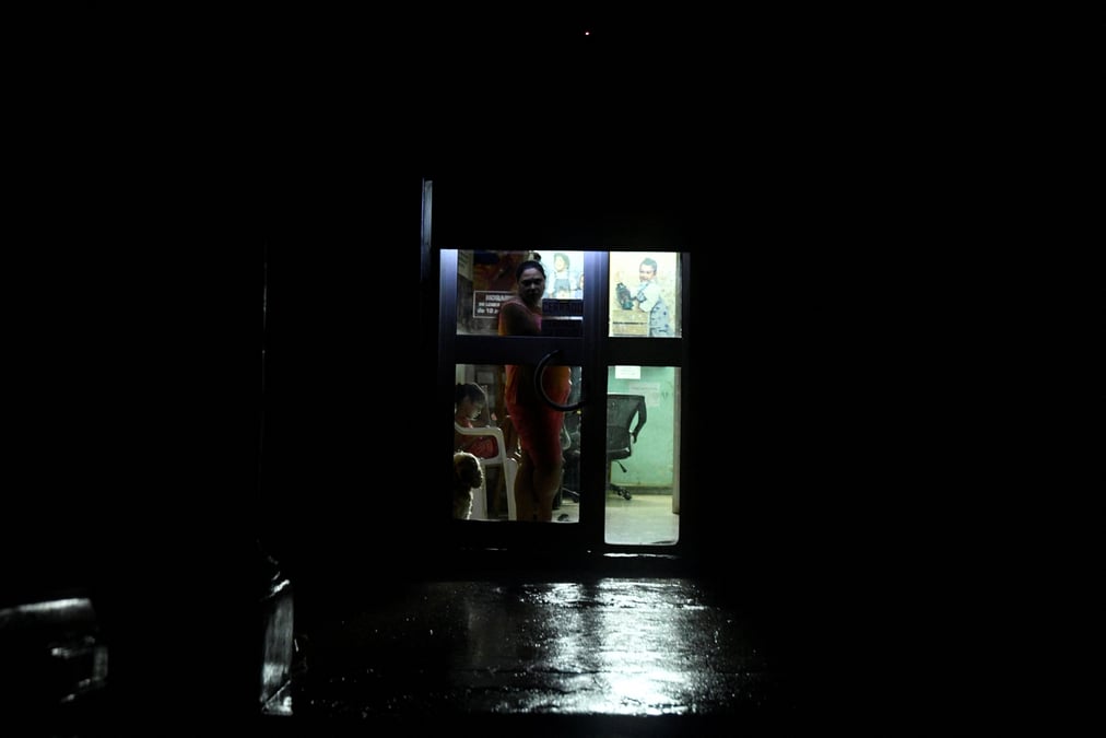 Une femme regarde d'une porte pendant que l'ouragan rafael touche terre a la havane, cuba