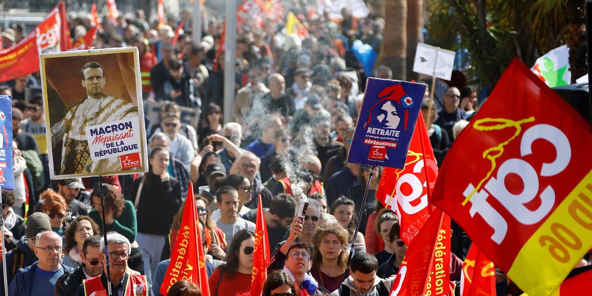 Des manifestants du syndicat cgt tiennent une pancarte representant le president francais emmanuel macron