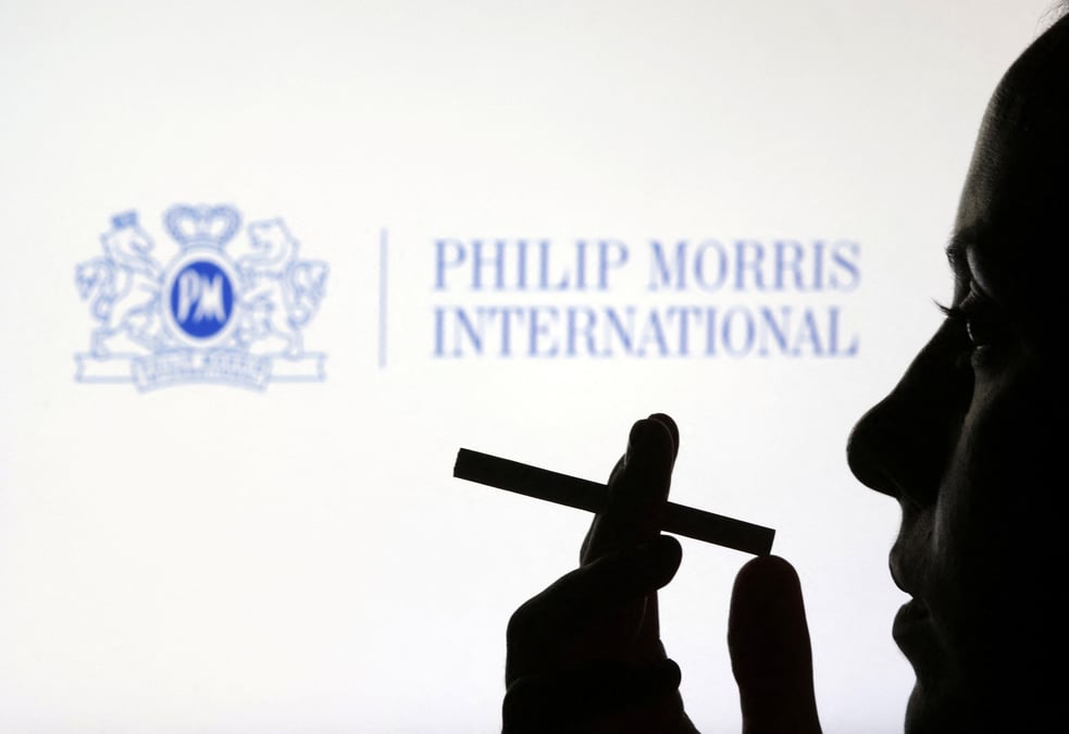 Une femme avec une cigarette devant le logo de philip morris international