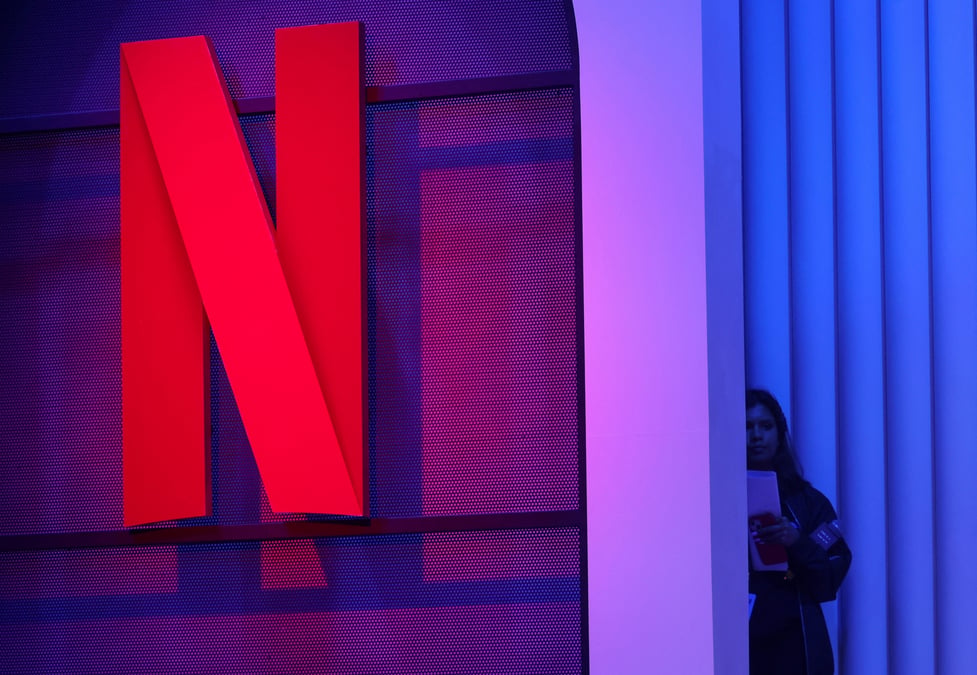 Une femme se tient a cote d'un logo de netflix lors d'un evenement a mumbai