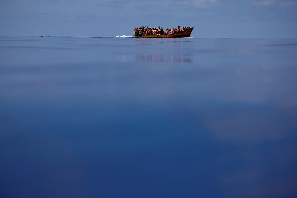 Des migrants naviguent sur un bateau en fer
