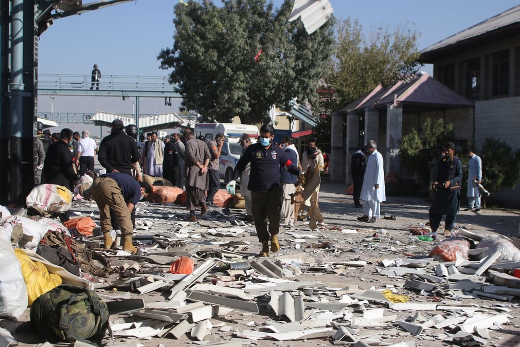 Un officier de police examine le site au milieu des debris apres l'explosion d'une bombe dans une gare ferroviaire a quetta.