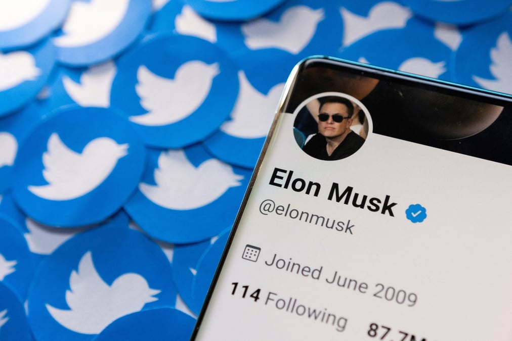 Le profil twitter d'elon musk sur un smartphone place sur des logos twitter