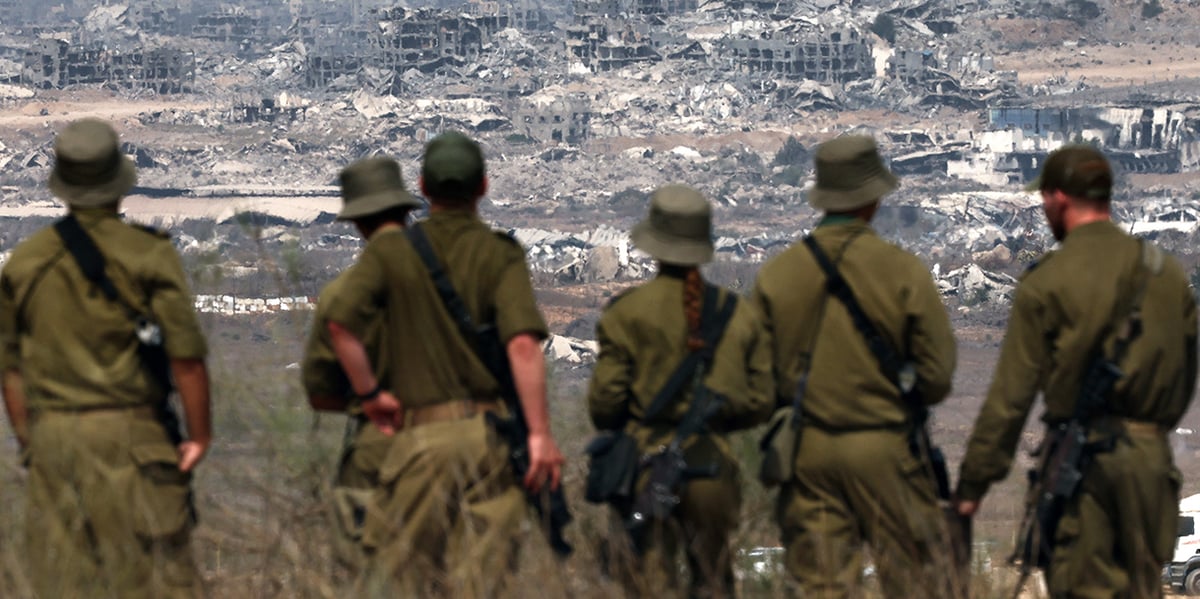 Des soldats israéliens regardent les ruines de Gaza.
