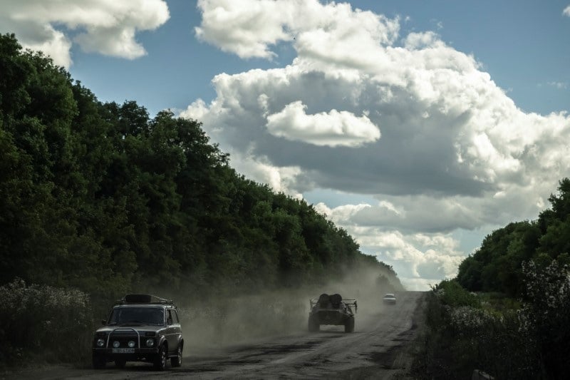 Des militaires ukrainiens montent a bord d'un vehicule blinde de transport de troupes pres de la frontiere russe, dans la region de sumy
