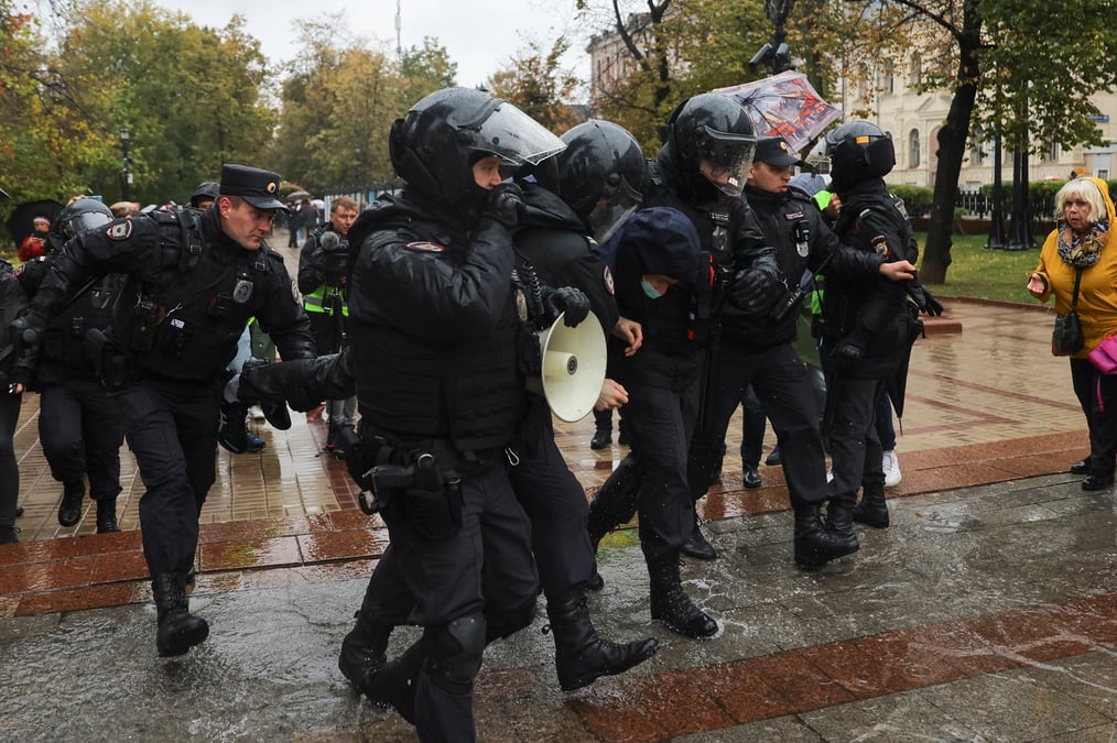 Des agents des forces de l'ordre russes detiennent une personne pendant un rassemblement a moscou