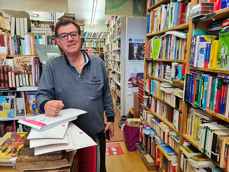 Hamid Kaighobadia prépare des commandes en ligne au milieu de sa librairie atypique