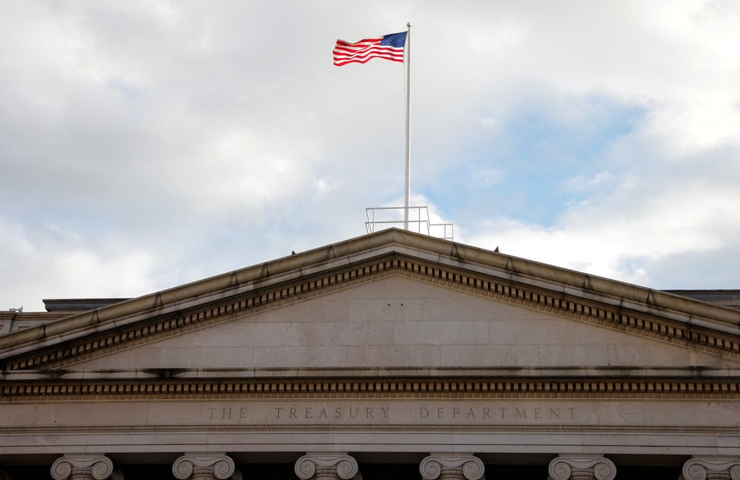Photo d'archives d'un drapeau americain qui flotte au-dessus du batiment du treasury building