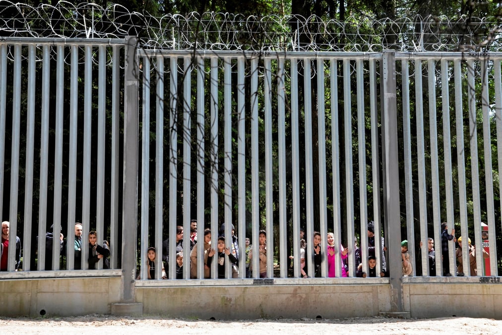 Des migrants se tiennent pres du mur a la frontiere entre la pologne et la bielorussie, pres de bialowieza