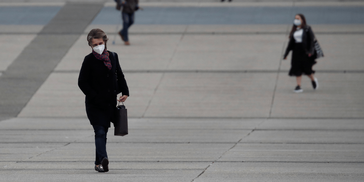 Coronavirus : une femme portant un masque marche dans le quartier La Défense à Paris
