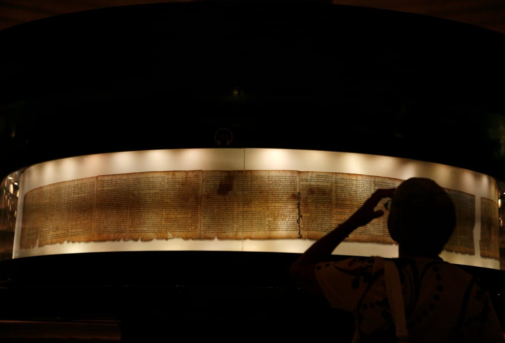 A visitor looks at a facsimile of the isaiah scroll displayed inside the shrine of the book at the israel museum in jerusalem
