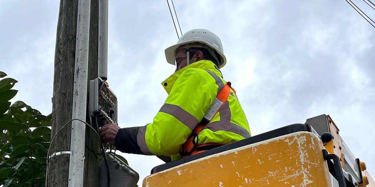 Un technicien enlevant des lignes du réseau cuivre.