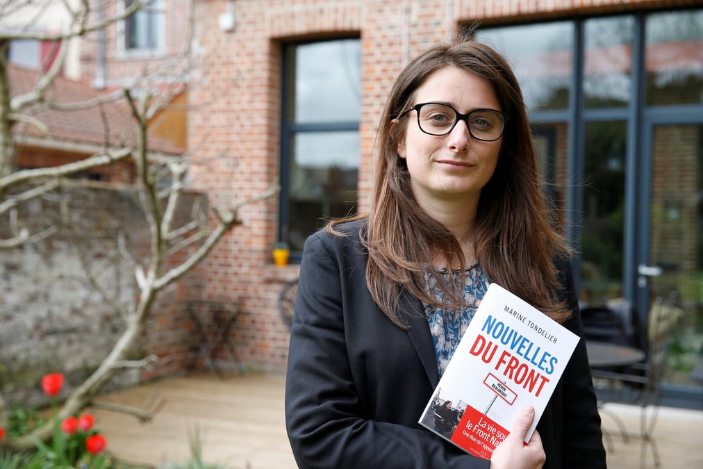 Marine tondelier dans son jardin a henin-beaumont en france, tenant son livre "nouvelles du front"