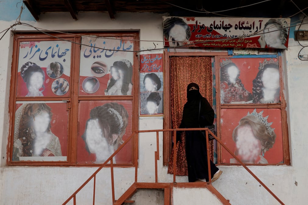 Une femme entrant dans un salon de beaute a kaboul, en afghanistan
