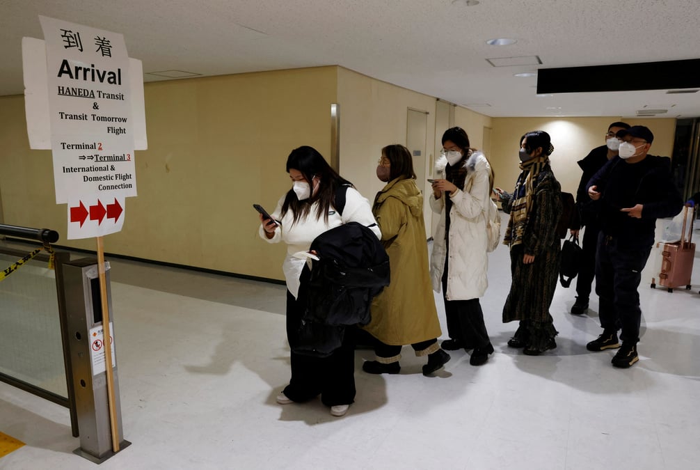 Des passagers d'un avion en provenance de pekin se dirigeant vers la zone de test du coronavirus
