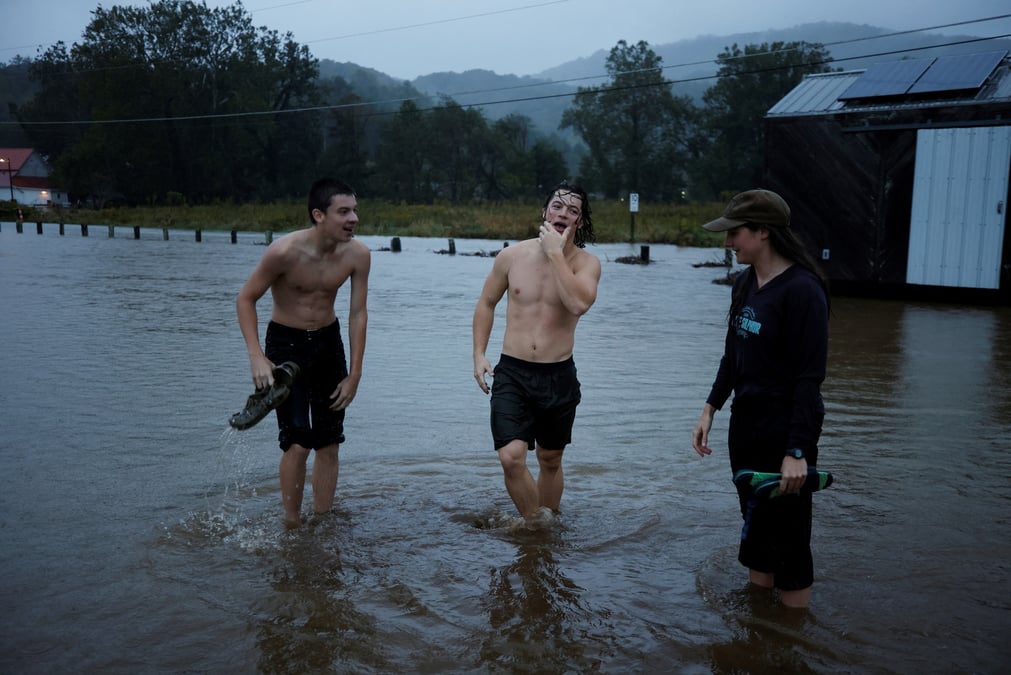 Des residents jouent dans les eaux inondees alors que l'ouragan helene approche dans les montagnes de caroline du nord, a valle crucis, en caroline du nord