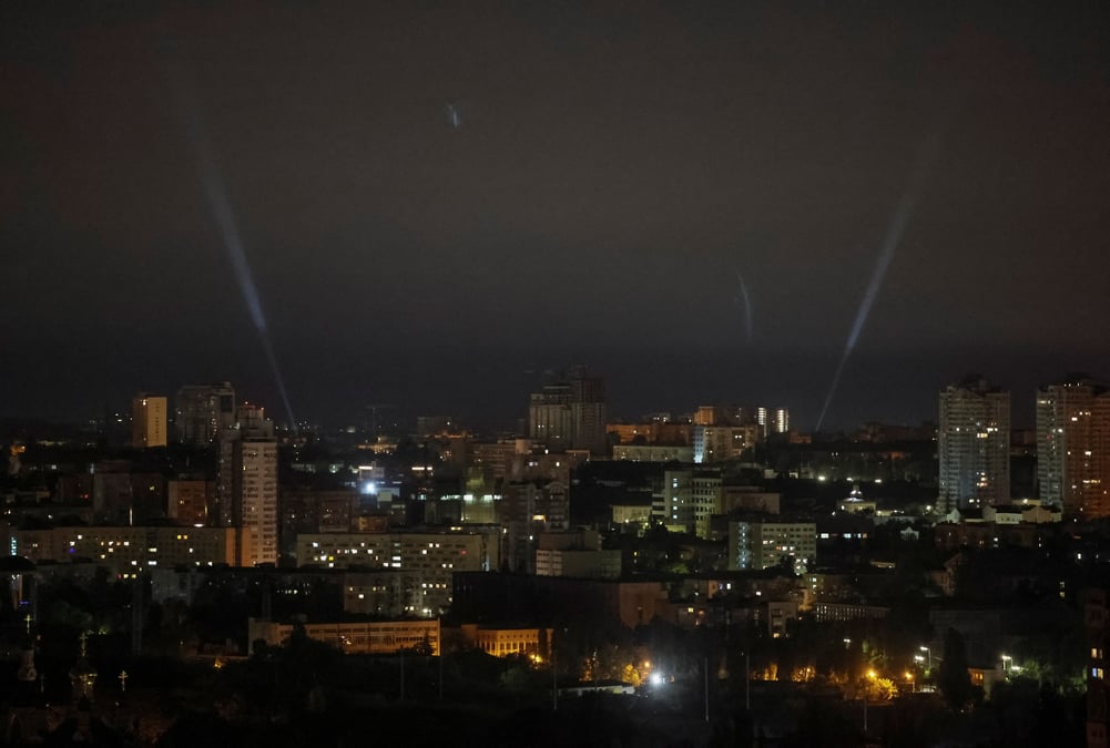 Des militaires ukrainiens utilisent un projecteur pour rechercher des drones dans le ciel de la ville