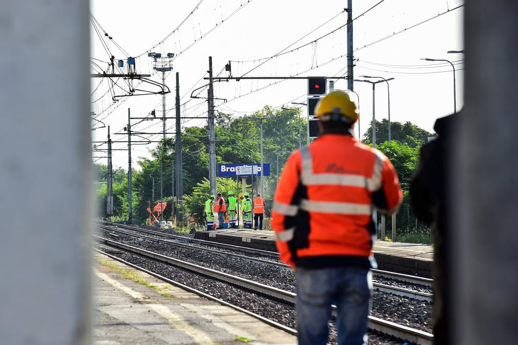 Photo des ouvriers qui marchent sur la voie ferree sur le lieu d'un accident ferroviaire dans lequel des travailleurs ont ete tues, en italie